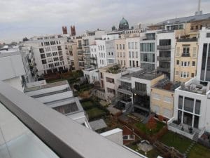 Kontrastierende Architekturstile in der Stadtlandschaft: Moderne trifft auf Bauhaus inmitten gemeinschaftlicher Grünflächen unter grauem Himmel