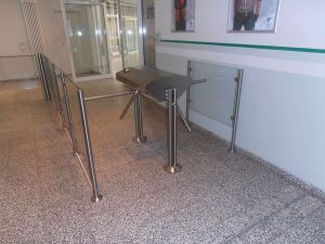 Gesicherter Zugang: Schwenktür aus Metall mit schwarzer Tischplatte als Aufsatz in einem Gebäude