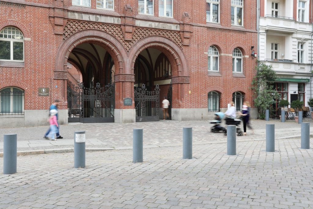 Architektonische Pracht erkunden: Fußgänger am gewölbten Eingang der Synagoge Berlin Rykestr. Eingangsbereich