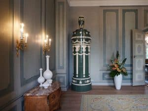 Gästehaus der Bundesregierung Schloss Meseberg: Erleben Sie Opulenz mit traditionellem Porzellanofen, antiken Möbeln und dekorativen Wandleuchten in diesem eleganten Zimmer